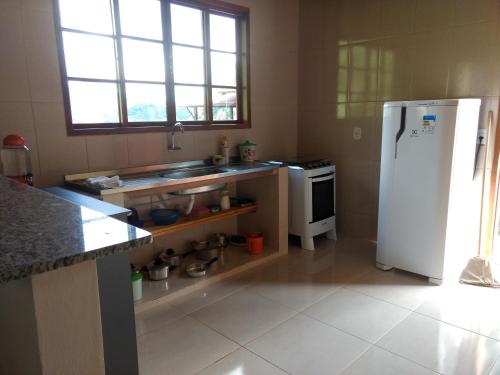 a kitchen with a white refrigerator and a stove at Casa Refúgio da Paz in Lumiar