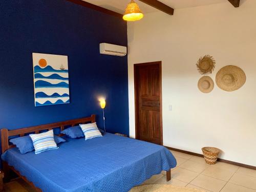 a blue bedroom with a bed with a blue wall at Villa Jonquet in Parajuru