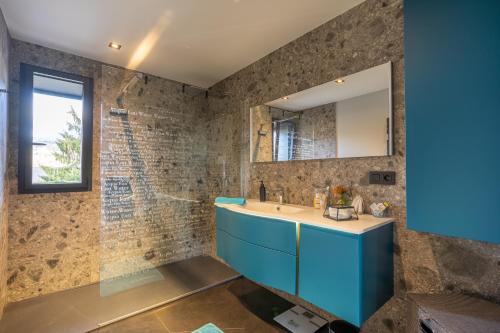 W łazience znajduje się niebieska umywalka i lustro. w obiekcie Villa Casanova w Aix-les-Bains