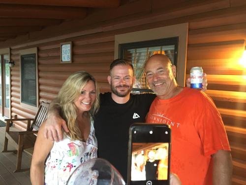 two men and a woman standing next to a cell phone at Crown Lake Resort in Horseshoe Bend