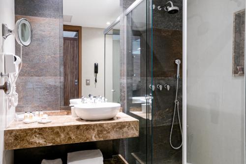 a bathroom with a sink and a glass shower at Arena Leme Hotel in Rio de Janeiro