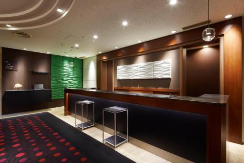 a bar in a room with a green wall at the b hachioji in Hachioji