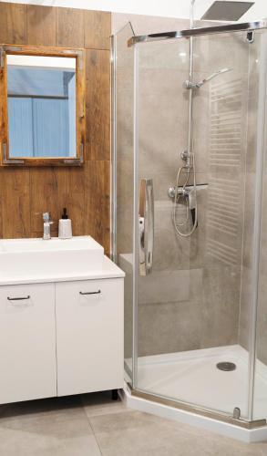 a white bathroom with a shower and a sink at RedCity LOFT in Żyrardów