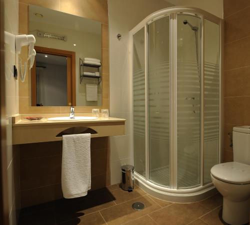 ein Bad mit einer Dusche, einem Waschbecken und einem WC in der Unterkunft Hotel Daymiel in Daimiel