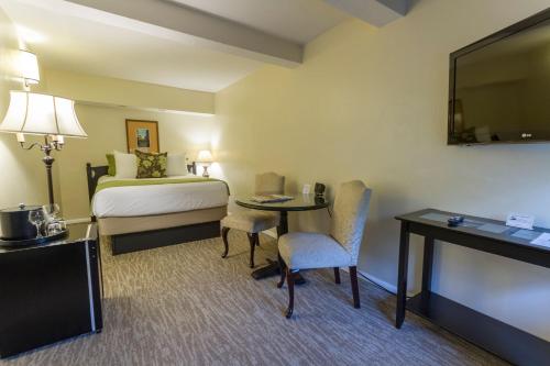 a hotel room with two beds and a table at Coast Village Inn in Santa Barbara