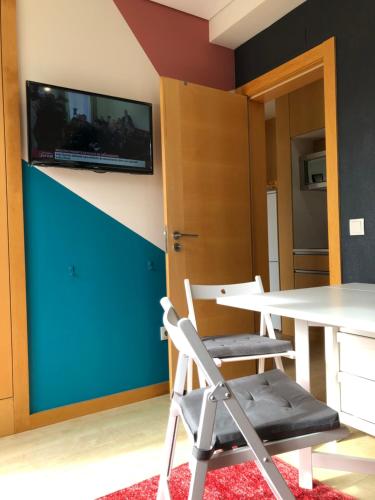 a room with a table and a tv on a wall at king's tower by Férias em Figueira in Figueira da Foz