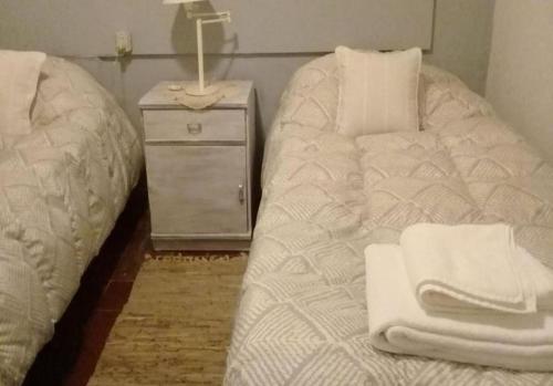 een slaapkamer met een bed en een dressoir met handdoeken bij Casa de Campo de Familiar in Tafí del Valle