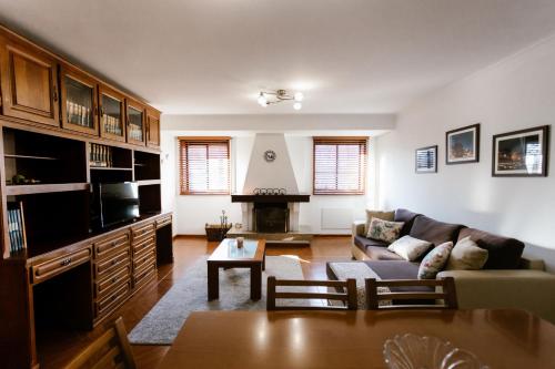 a living room with a couch and a fireplace at Castle Apartment in Guimarães