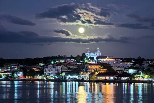 a city at night with the moon in the sky at La Posada De Don Jose in Flores