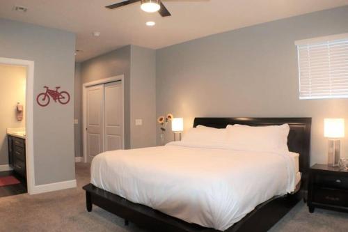 ein Schlafzimmer mit einem weißen Bett und einem roten Fahrrad an der Wand in der Unterkunft Exclusive Retreats Moab 3369 in Moab