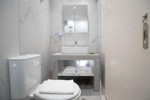 a white bathroom with a sink and a toilet at Elenas home in Vasiliki