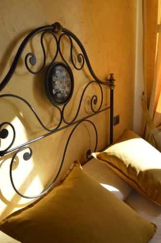 a bed with a metal headboard with a picture on it at Agriturismo Cascina Rabalot in Diano dʼAlba