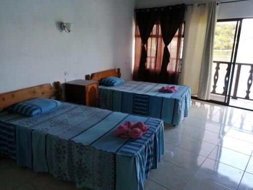 a room with two beds and a television in it at La Posada De Don Jose in Flores