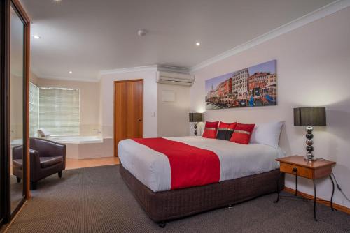 a bedroom with a large bed with a red blanket at Aspley Carsel Motor Inn in Brisbane
