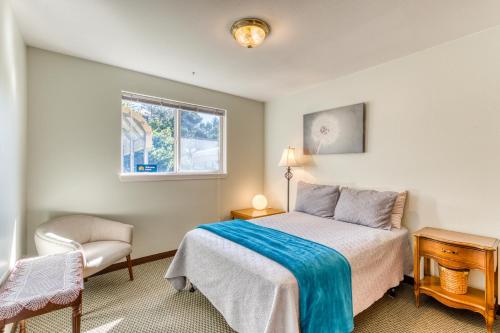 ein Schlafzimmer mit einem Bett und einem Stuhl und einem Fenster in der Unterkunft Bayview Cottage in Barview