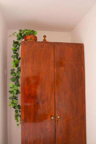 a wooden cabinet with a greenreath on top of it at Casa Londres in Estoril