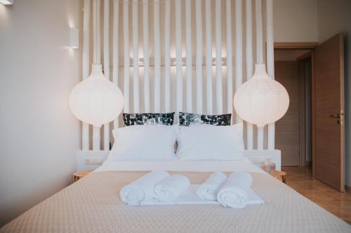 a bedroom with a bed with three towels on it at Youtopia Ios Villas in Ios Chora