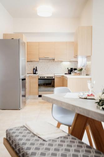 a kitchen with a table and chairs and a refrigerator at Youtopia Ios Villas in Ios Chora