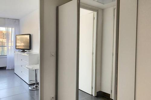 einen Flur mit einem Spiegel und einem TV im Zimmer in der Unterkunft Great studio with a sea view and parking in 400 meters from Monaco in Beausoleil