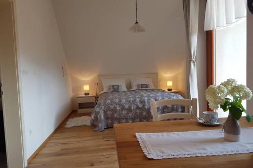 a bedroom with a bed and a table with flowers on it at Castle View Nest in Bled