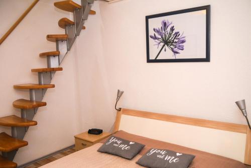 Zimmer mit einer Treppe und 2 Kissen auf einem Bett in der Unterkunft Ferienwohnung Am Elberadweg in Dresden