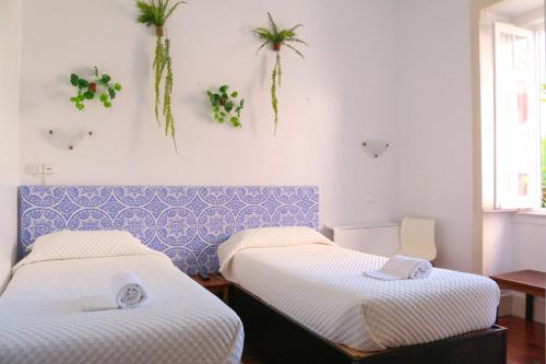 two beds in a room with plants on the wall at Casa Londres in Estoril