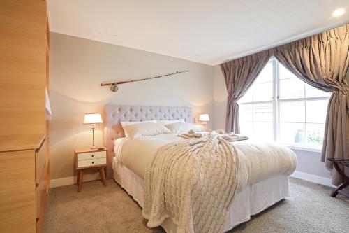 因弗卡吉爾的住宿－運輸世界洛奇公寓，一间卧室设有一张大床和一个窗户。