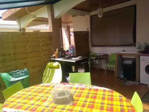 a kitchen with a table and green chairs in a room at casa DOM in Le Robert