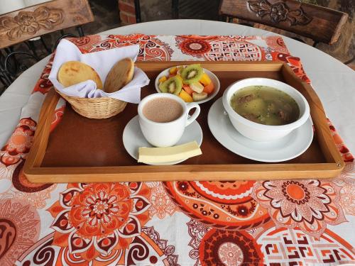 a tray with a bowl of soup and a cup of coffee at Hotel Quinta de Santa Ana in Tibasosa