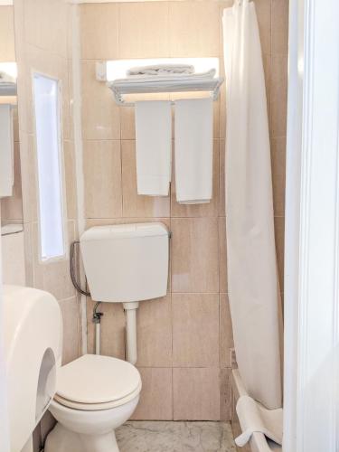 a white bathroom with a toilet and a shower at Casa Londres in Estoril