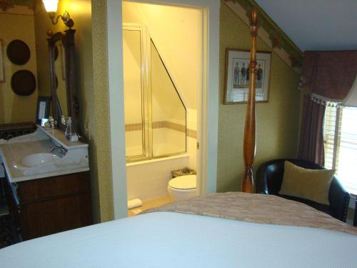 um quarto com uma casa de banho com uma cama e um lavatório em The Village Inn of Woodstock em Woodstock