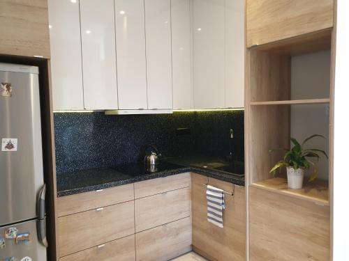 a kitchen with white cabinets and a black counter top at Apartament w zieleni do wynajęcia blisko jeziora in Środa Wielkopolska