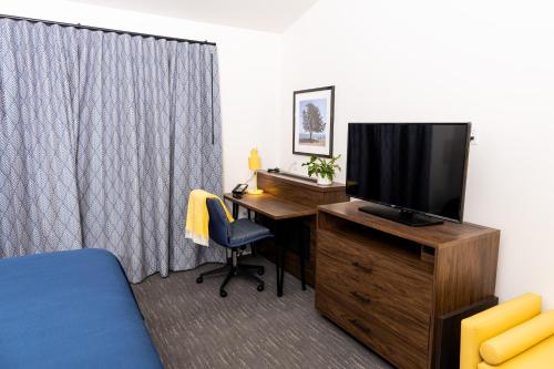 a room with a desk with a television and a bed at La Playa Inn Santa Barbara in Santa Barbara