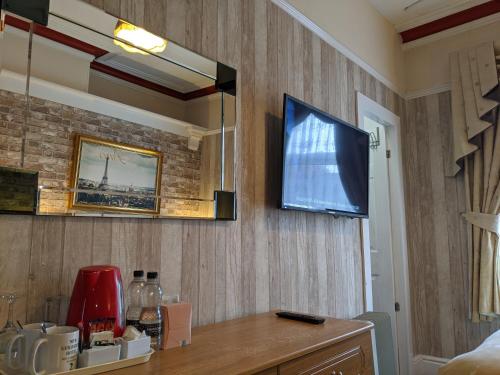a living room with a tv on the wall at The New Guilderoy Hotel in Blackpool