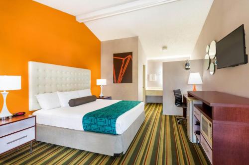 um quarto de hotel com uma cama grande e uma secretária em Howard Johnson by Wyndham Phoenix Airport/Downtown Area em Phoenix