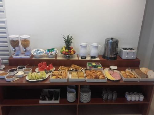 een tafel gevuld met verschillende soorten voedsel op borden bij Altitud 720 Hotel, Aparts & Spa in Villa General Belgrano