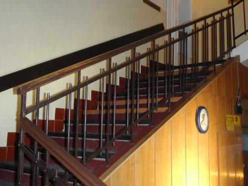 a staircase in a building with a clock on the wall at Penzion Partizan in Smokovce