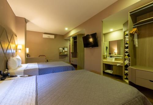 ein Hotelzimmer mit 2 Betten und einem Waschbecken in der Unterkunft Hotel Glow Point - Mulza in León