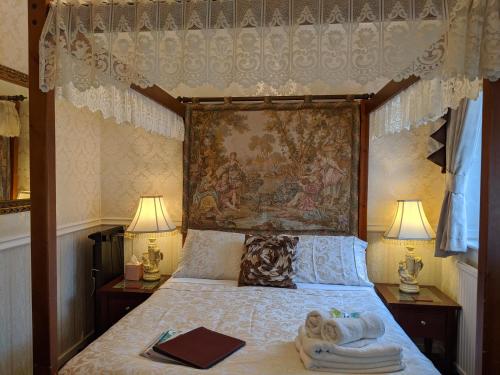 a bedroom with a canopy bed with towels on it at The New Guilderoy Hotel in Blackpool