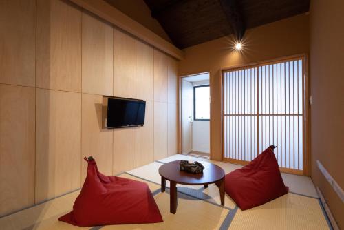 a room with red pillows and a table and a tv at 壬生宿 MIBU-JUKU Shichijo-Umekoji in Kyoto