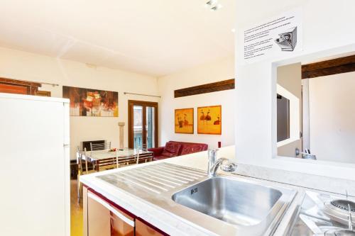 a kitchen with a sink and a living room at Vip Venice Apartments and Rooms San Marco 5134 e 274 in Venice