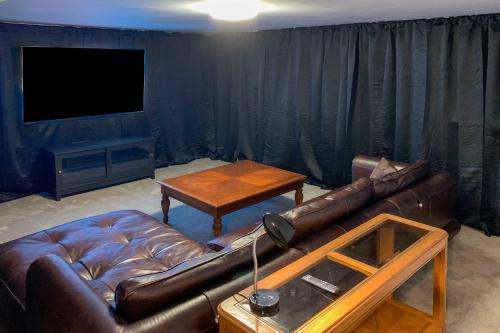 a living room with a leather couch and a table at Downtown Cedar City House Less Than half Mi to SUU Campus! in Cedar City
