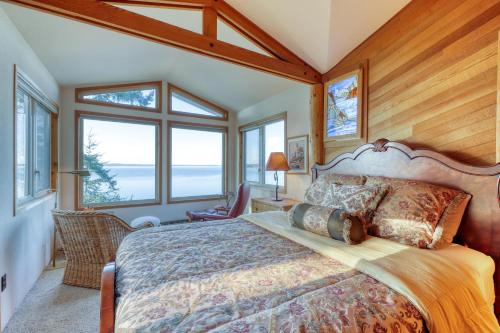 a bedroom with a large bed with a large window at Seascape Lodge in Freeland