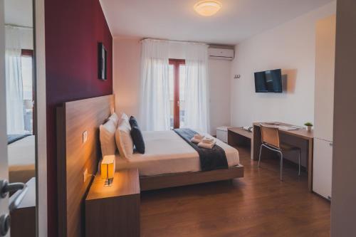 a hotel room with a bed and a desk and a table at Trip Room & Breakfast in Reggio di Calabria