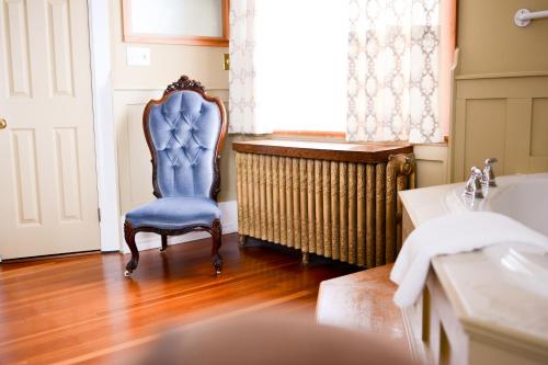 baño con silla azul y lavamanos en Dashwood Manor Seaside Bed & Breakfast en Victoria