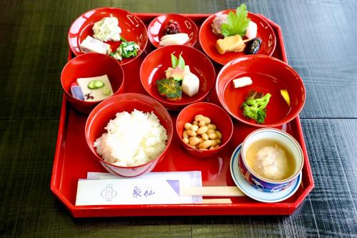 a red tray with bowls of food on a table at Kuraya Kamigojocho in Kyoto