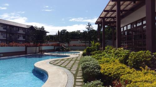 een zwembad voor een gebouw bij StayPlus Metro Manila Solano Hills Tropical Home Suite in Manilla