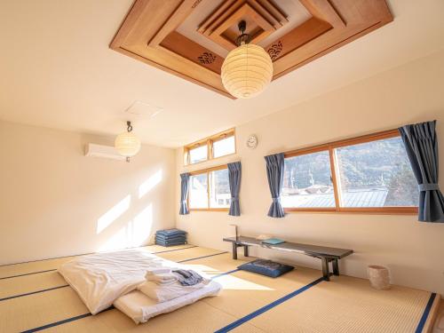 a bedroom with a bed in a room with windows at 4S STAY Awaikeda Ekimae in Miyoshi
