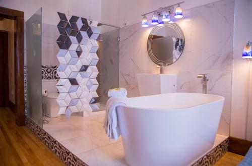 a bathroom with a white tub and a mirror at School 31 Lofts in Rochester