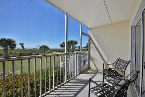 a wooden bench sitting in front of a balcony at Seaside Inn in Sanibel